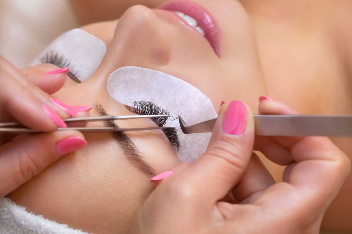 performing eyelash extensions service at beauty salon