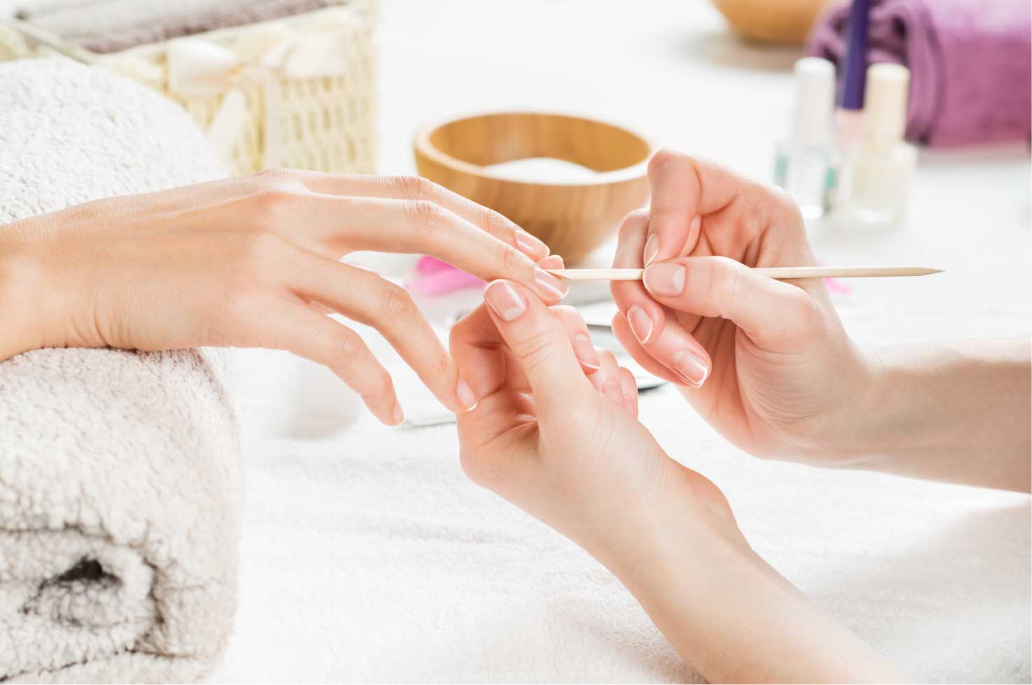 performing manicure nail service to women's nails